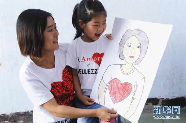 5月10日，在河北唐山市豐潤區(qū)迎賓路幼兒園開展的“媽媽，我愛你”主題活動中，陳悅寧小朋友將自己的繪畫作品送給媽媽作為節(jié)日禮物。 新華社發(fā)（朱大勇 攝）