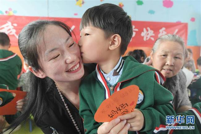 5月10日，在湖北省襄陽市一家幼兒園舉辦的母親節(jié)主題活動中，一名小朋友將自己制作的賀卡獻給媽媽。 新華社發(fā)（安富斌 攝）