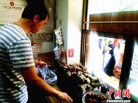 圖為凌君道正在將粽子裝袋進(jìn)行售賣(mài)。　高康迪 攝